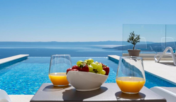 Breakfast on the sunny outdoor terrace of a luxurious Croatian villa with a view of the beautiful island of Brač