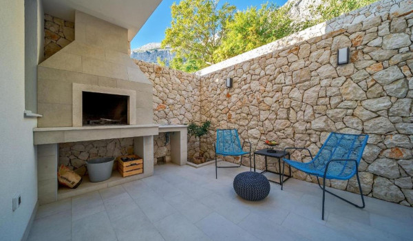 Outdoor wood-burning fireplace on the property of a Croatian fully fenced villa for a holiday with friends