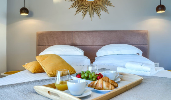 A spacious modern bedroom with access to a terrace with a seating area and a view of the Brač channel