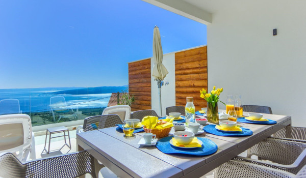 Dining table with chairs on the terrace of the Croatian luxury villa White Diamond for vacation and rent