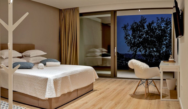 An airy, spacious bedroom with a comfortable king-size bed and access to the terrace