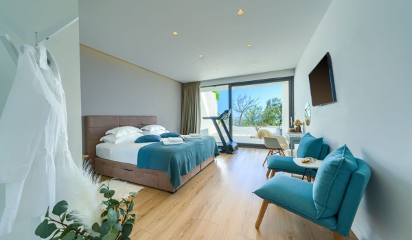 A luxuriously decorated bedroom with a king-size bed, exit to the terrace and numerous details