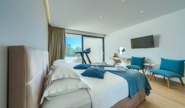 A luxuriously decorated bedroom with a king-size bed, exit to the terrace and numerous details