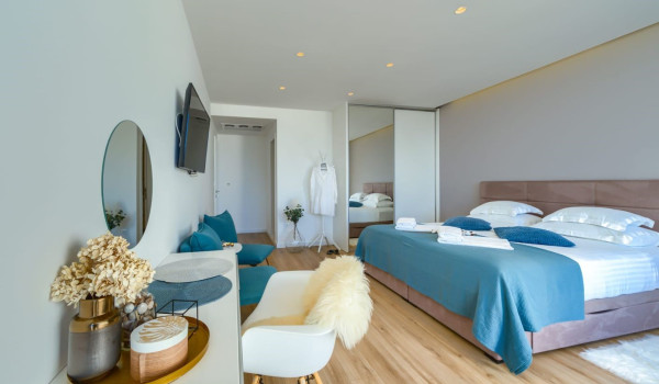 A luxuriously decorated bedroom with a king-size bed, exit to the terrace and numerous details