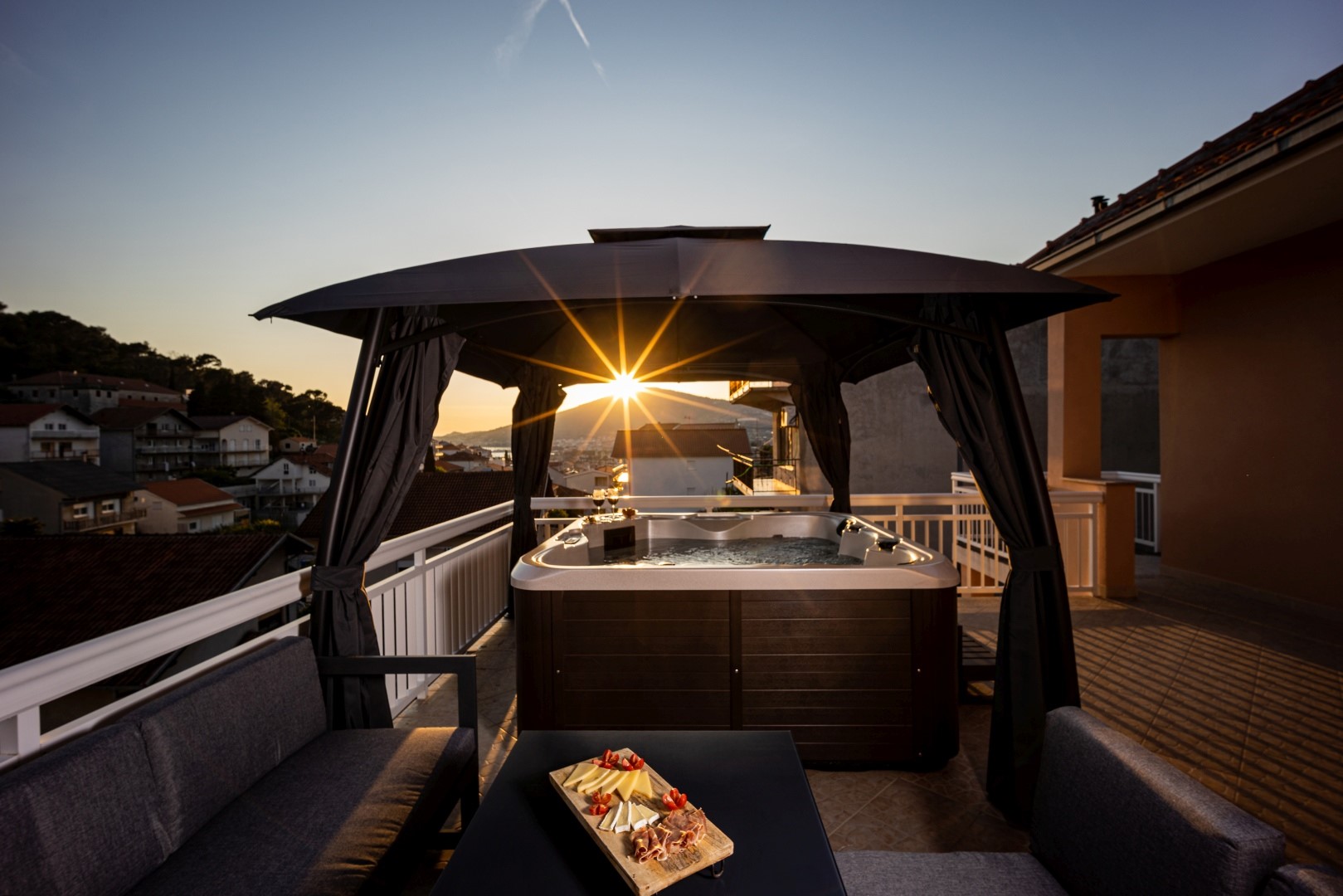 Privater Whirlpool auf der Terrasse einer modernen Luxusvilla zum Mieten und Urlaub mit Blick auf das Meer und die Stadt Trogir
