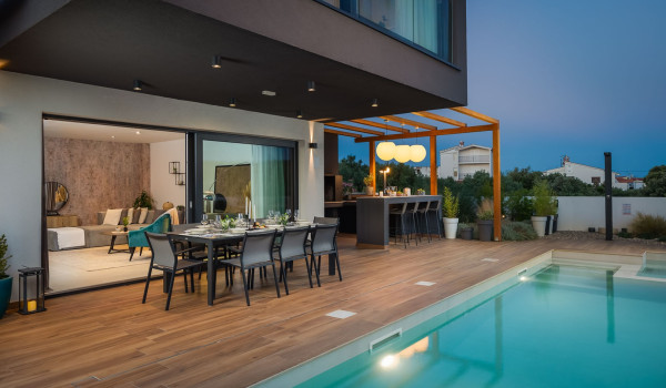 Fenced yard of the luxurious Dalmatian villa for rent and vacation with an outdoor dining table and a private pool in Rogoznica