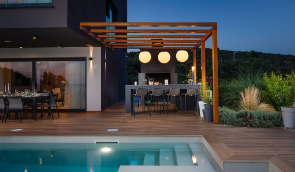 Outdoor dining table with chairs next the barbecue on the spacious patio of the pet-friendly Croatia vacation home Indigo