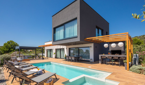 Fenced patio with private pool in front of the luxury Dalmatian rental home in Razanj near Rogoznica