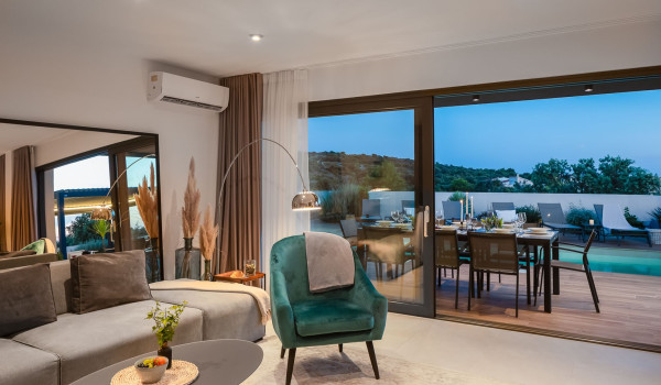 Modern interior of the elegant living room with an angular sofa and a decorative armchair in the villa for rent and vacation Indigo in Razanj near Rogoznica