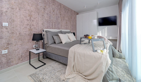 Spacious bedroom with a king size bed, SAT TV and an access to the balcony in the villa for rent and vacation Indigo in Razanj