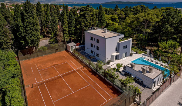 Dense pine forest surrounding the private property of modern villa Velvet Bourbon Split and tennis court