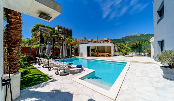 View of the Kozjak mountain from the private fenced terrace with pool, deckchairs and outdoor summer kitchen