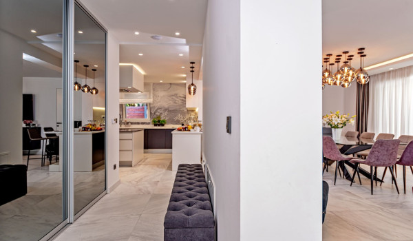 A hallway leading to the modern kitchen with dining area