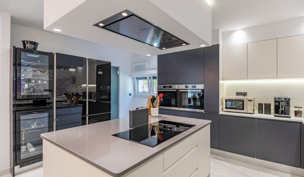 Spacious modern equipped kitchen with a large kitchen island, stove, two ovens and a microwave oven