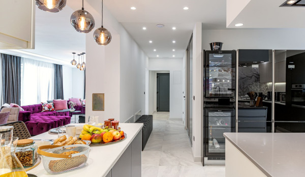 View of the hallway and living room from the spacious modern kitchen with wine coolers