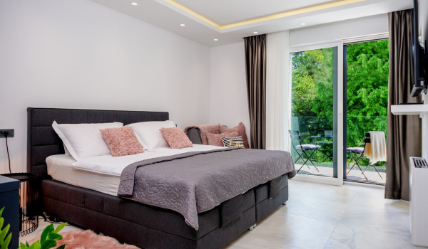 Contemporary bedroom interior with king size bed and access to the balcony