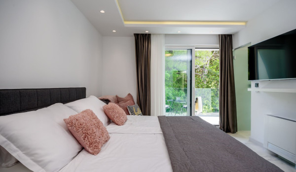 Comfortable king size bed in front of the LCD TV next to the exit to the balcony