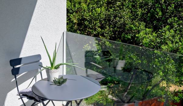 Corner with seating area on the balcony and view of nature and pine trees