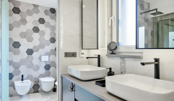 Washbasins in the modern, en suite bathroom filled with light and large mirrors