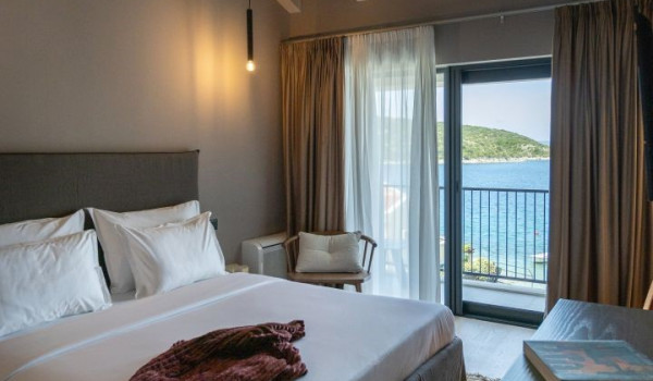 A bedroom with a comfortable king-size bed, an en suite bathroom and a view of the sea and the islands around Slano