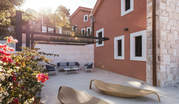 A view of the covered seating area and modern leaf-shaped lounge chairs on the property of a Dalmatian luxury holiday villa