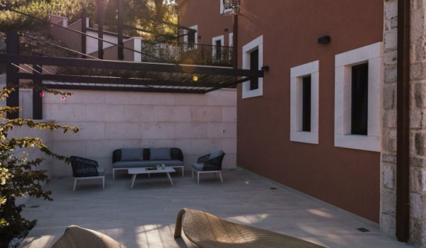 A view of the covered seating area and modern leaf-shaped lounge chairs on the property of a Dalmatian luxury holiday villa