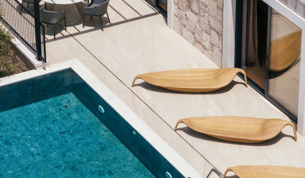 A view of the heated infinity pool with modern deckchairs on the property of a Dalmatian luxury villa
