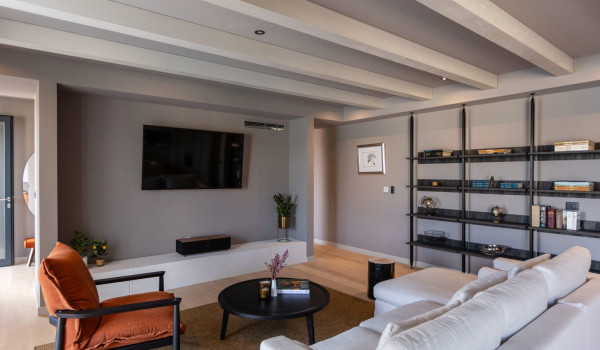 A richly decorated living room with a comfortable sofa and TV on the ground floor of a modern villa for rent and vacation
