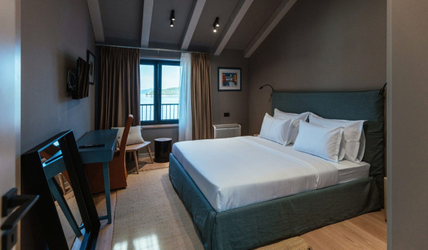 A bedroom with a comfortable king-size bed, an en suite bathroom and a view of the sea and the islands around Slano