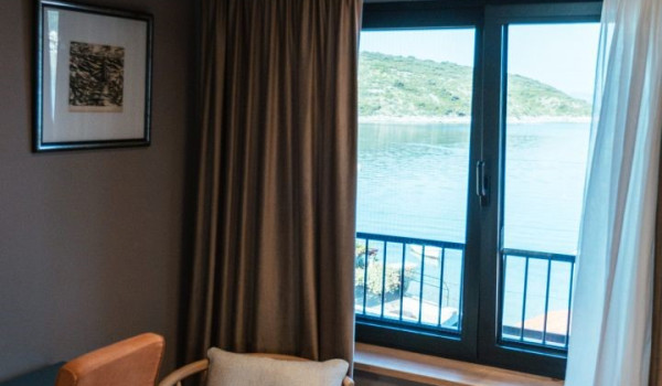 A bedroom with a comfortable king-size bed, an en suite bathroom and a view of the sea and the islands around Slano
