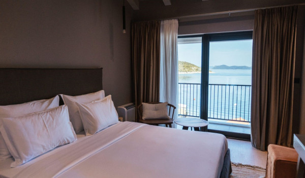 A bedroom with a comfortable king-size bed, an en suite bathroom and a view of the sea and the islands around Slano