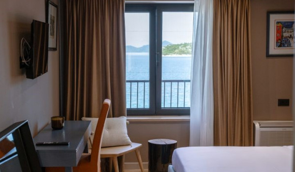 A bedroom with a comfortable king-size bed, an en suite bathroom and a view of the sea and the islands around Slano