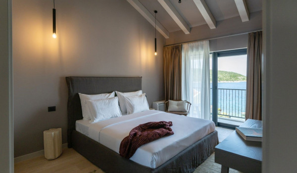 A bedroom with a comfortable king-size bed, an en suite bathroom and a view of the sea and the islands around Slano