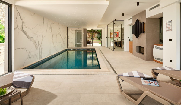Sun loungers by the private indoor pool in the family holiday home Thalia with gym in Marina