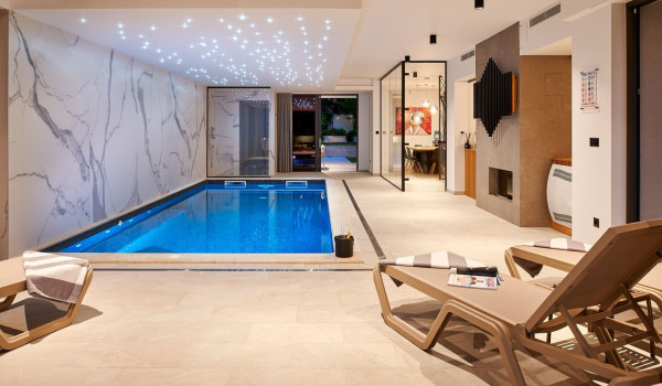 Sun loungers by the private indoor pool in the family holiday home Thalia with gym in Marina