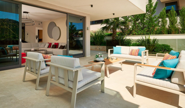 Outdoor seating corner with a table in front of the entrance to the living room of the villa for family holiday in Marina