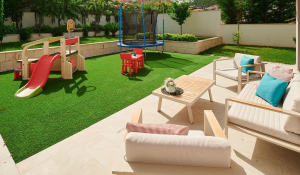 Private garden with a children's playground and an outdoor seating corner