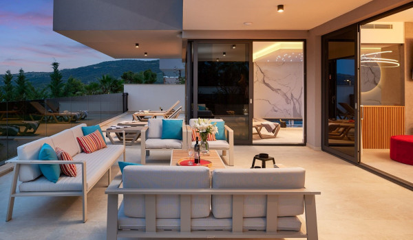 Roofed part of the terrace with outdoor seating furniture and table in front of the entrance to the villa Thalia in Marina