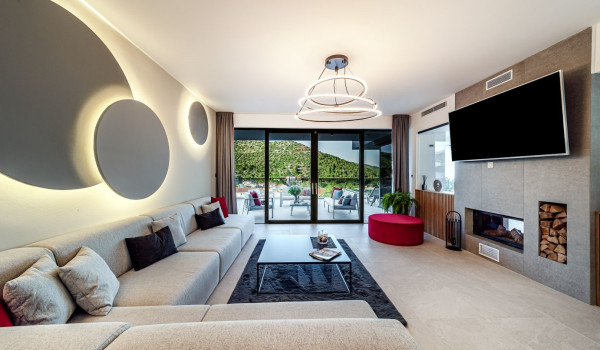 Elegantly decorated living room with a SAT TV and a corner sofa in the villa Thalia for vacation and rent