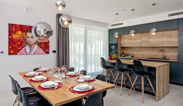 Dining table and kitchen island in the fully equipped kitchen of the vacation villa Thaliawith an indoor pool