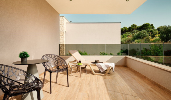 Sun lounger and a seating corner with two chairs and a table  on the balcony of the luxury Croatia villa Thalia in Marina