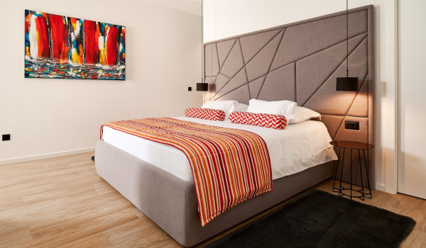 Comfortable king size bed in the airy bedroom of the luxurious villa for rent Thalia with an indoor pool
