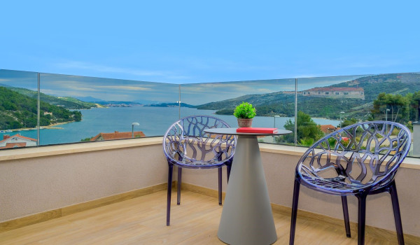 Seating corner with two chairs and a table on the private balcony of the villa Thalia with a sea view