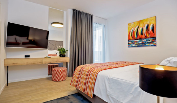 Spacious bedroom with a king size bed, SAT TV and a seating corner in the villa Thalia in Marina near Trogir