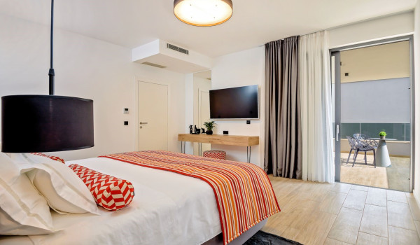 Airy bedroom with a comfortable king size bed, SAT TV and exit to the private balcony