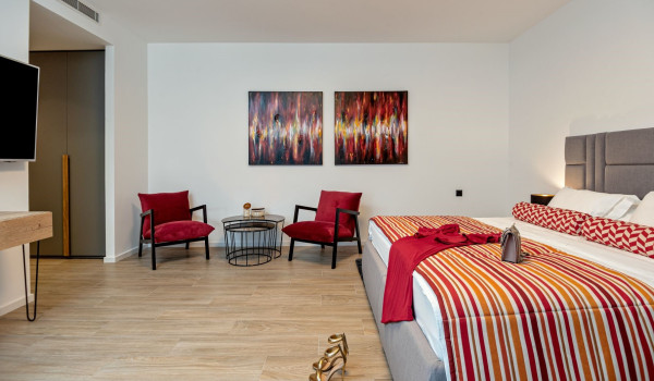 Comfortable king size bed, seating corner and SAT TV in the spacious bedroom of the modern Ceroatian villa with an indoor pool Thalia
