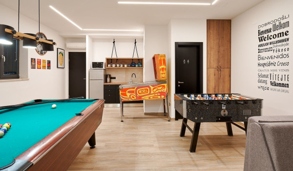 Bright game room with pool table, foosball, pinball machine and darts in the game room of the villa Thalia