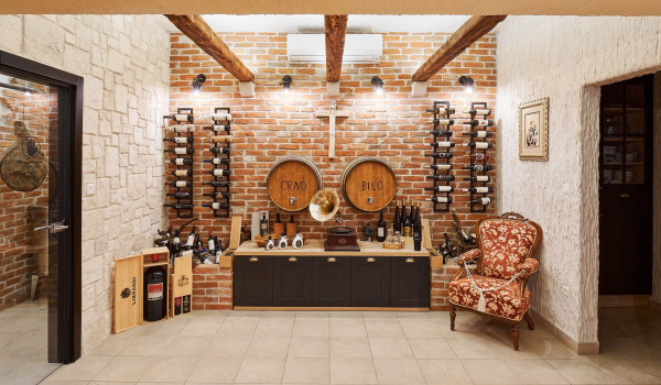 Wine collection and seating corner in the tavern of the vacation home Thalia with an indoor pool