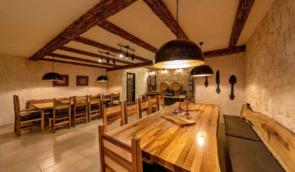 Private tavern with wooden tables and chairs in the basement of the luxury Croatian villa Thalia with pool and gym