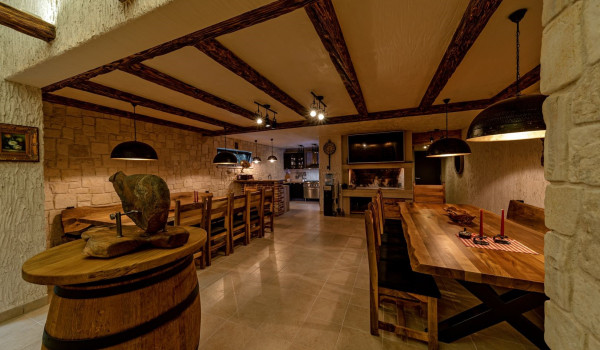 Private tavern with wooden tables and chairs in the basement of the luxury Croatian villa Thalia in Marina